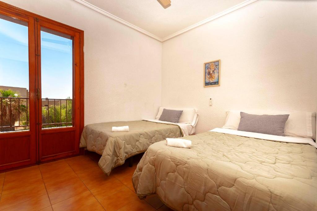 Dormitorio con dos camas y balcón